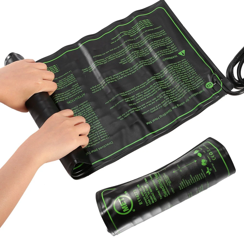 Hands rolling up a black seedling heat mat with green printing, used for germinating seeds and maintaining optimal plant temperatures.