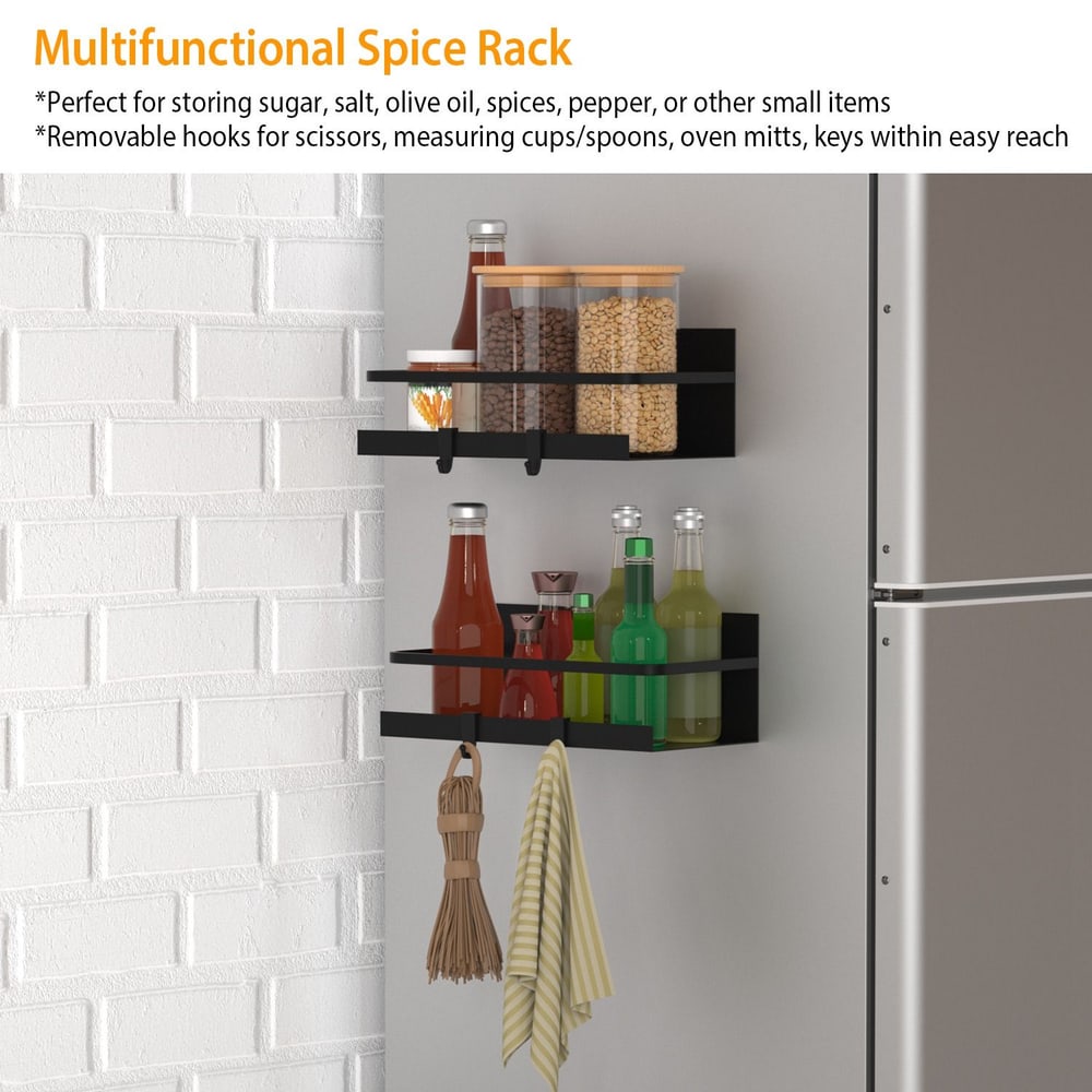 Multifunctional spice rack with two black shelves holding various condiments, spices, and dry goods, featuring removable hooks for kitchen tools such as scissors and measuring spoons, mounted on a white brick wall.