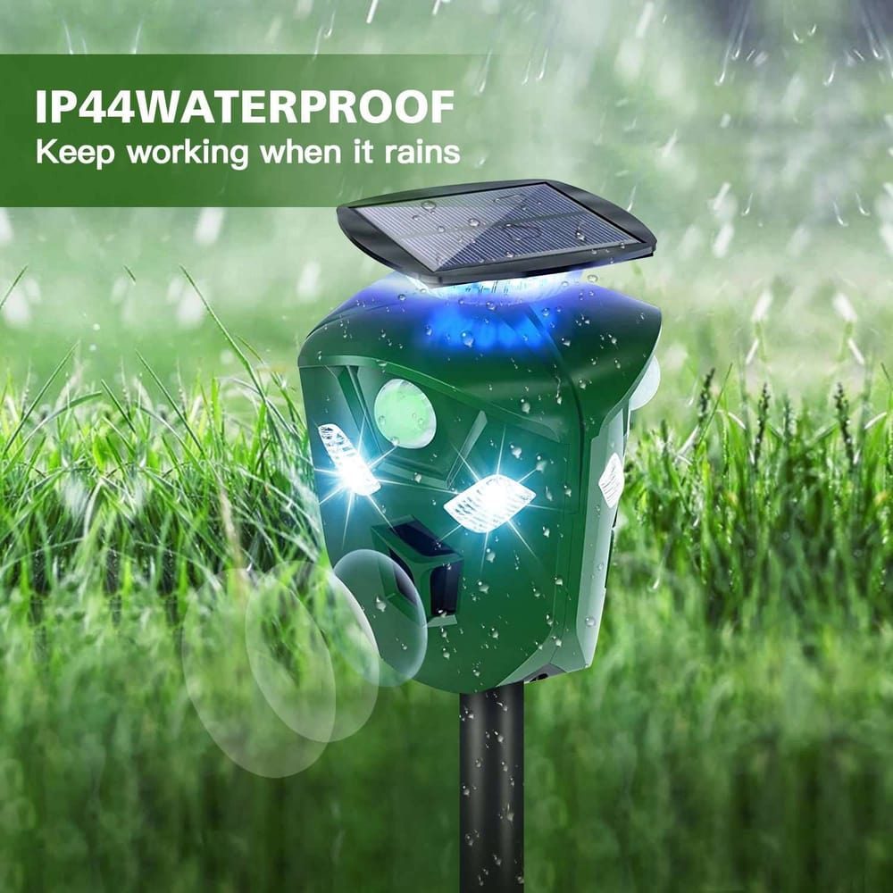 Waterproof solar-powered pest repeller with motion sensor and LED lights, designed for outdoor use in rainy weather, installed in a grassy area.