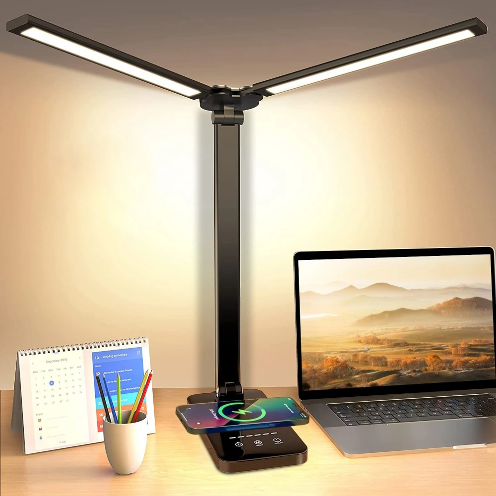 Modern LED desk lamp with wireless charging pad, laptop, calendar, and colorful pens on a wooden desk, creating an organized workspace ambiance.