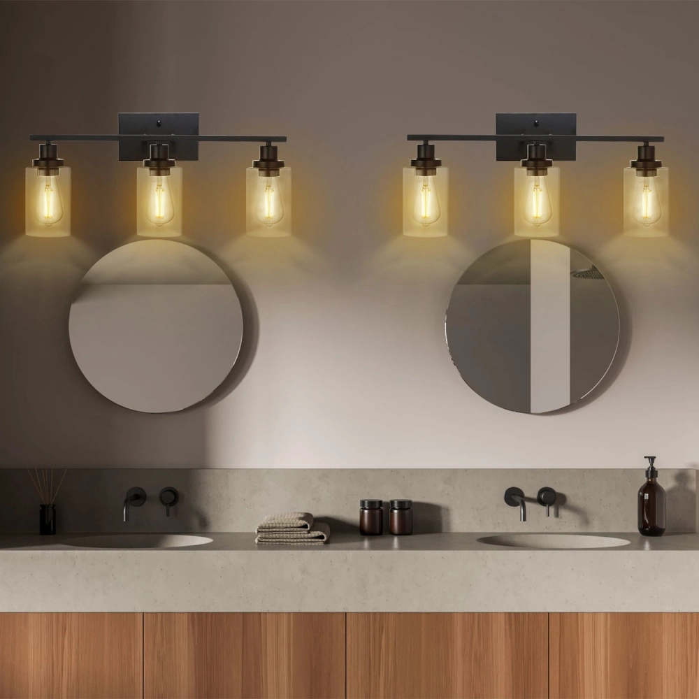 Industrial-style bathroom lighting fixture with three glass pendant bulbs illuminating a modern vanity with dual circular mirrors and a sleek concrete countertop.