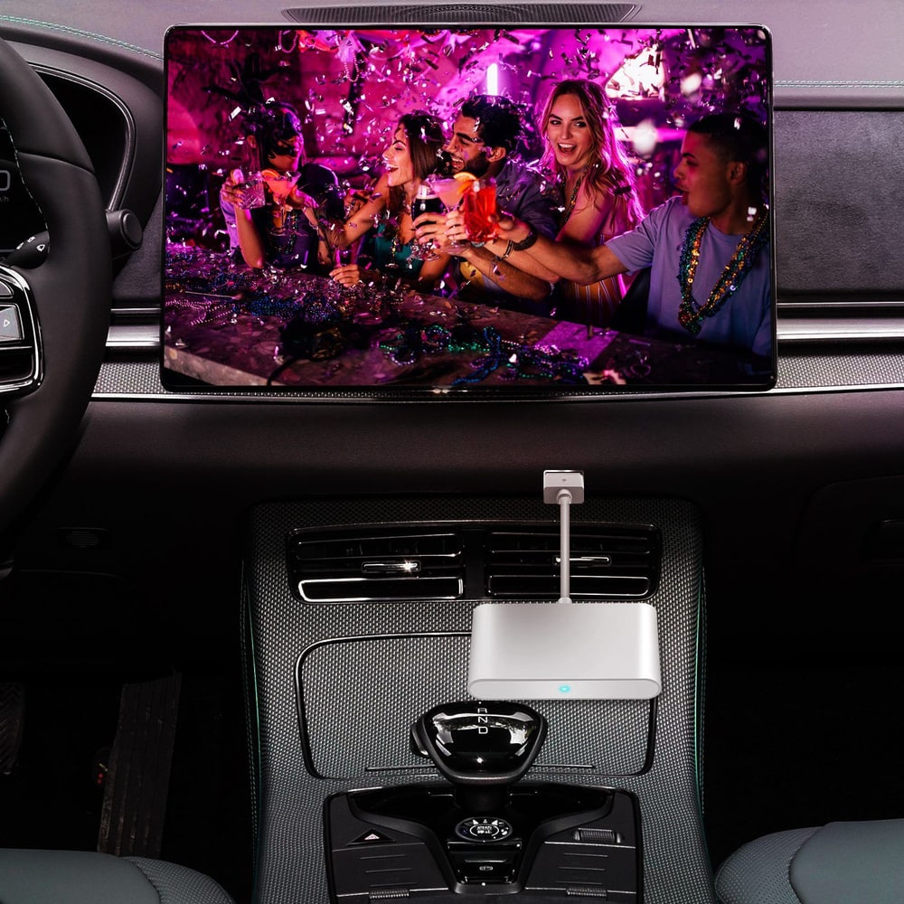 Car interior featuring a large screen displaying a vibrant party scene with friends enjoying drinks, equipped with a stylish and modern multimedia dongle for connectivity.