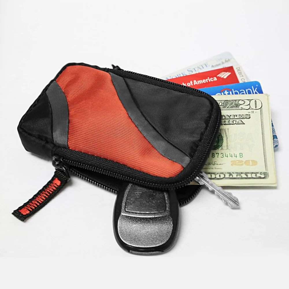 Compact black and red zippered wallet with cash and credit cards partially visible, featuring a car key fob resting on top.