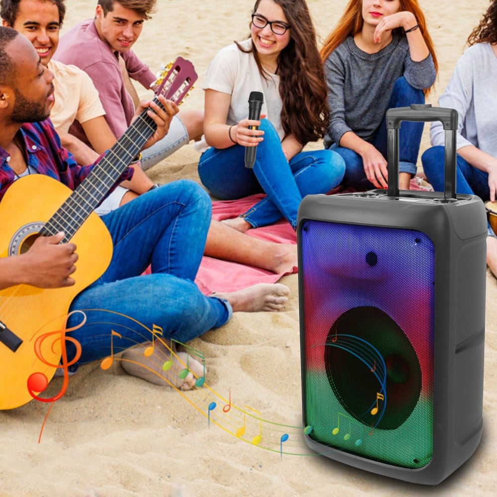 Portable wireless speaker with colorful LED lights, surrounded by a group of friends enjoying music and singing on the beach.