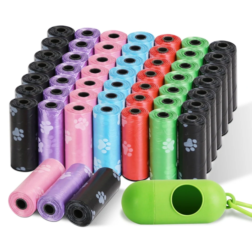 Colorful dog waste bags in rolls, featuring various colors and paw print designs, accompanied by a green dispenser for easy storage and access.