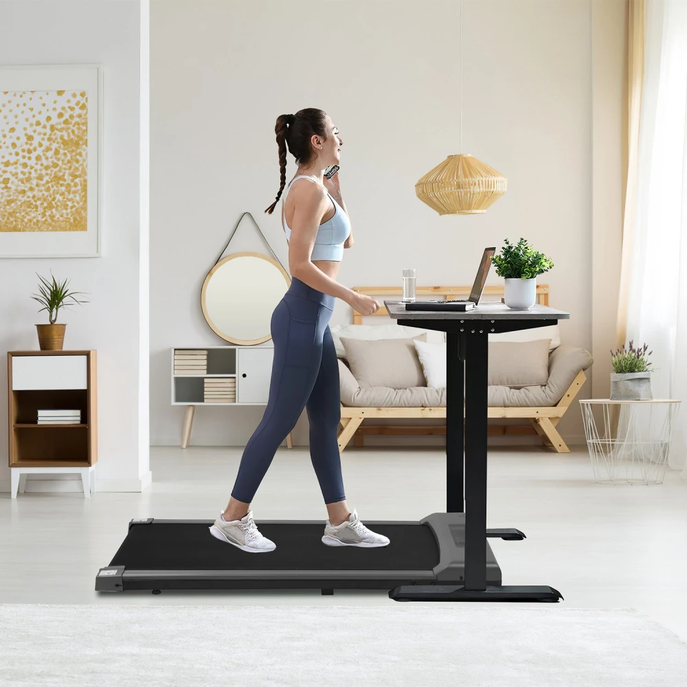 Home office treadmill with adjustable standing desk, featuring a woman walking while using a laptop in a modern living space.