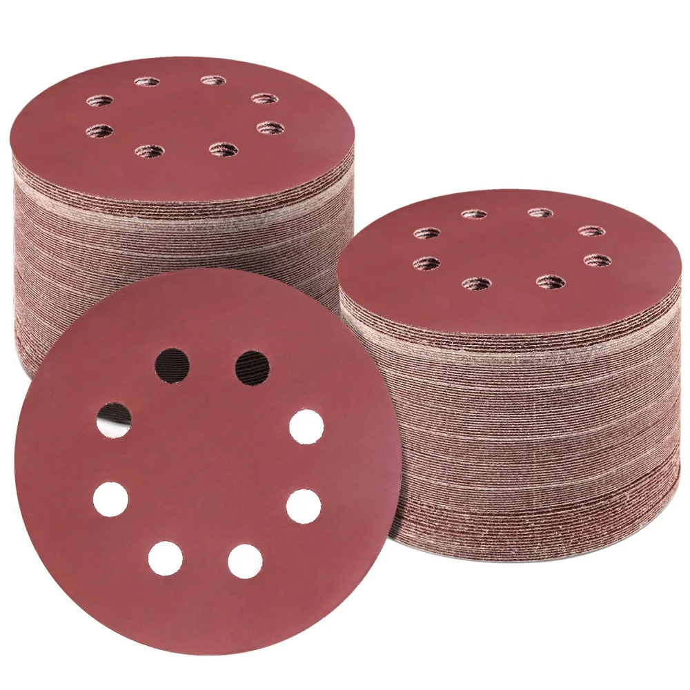 Rolls of red sanding discs with multiple holes for dust extraction, ideal for wood and metal sanding projects.