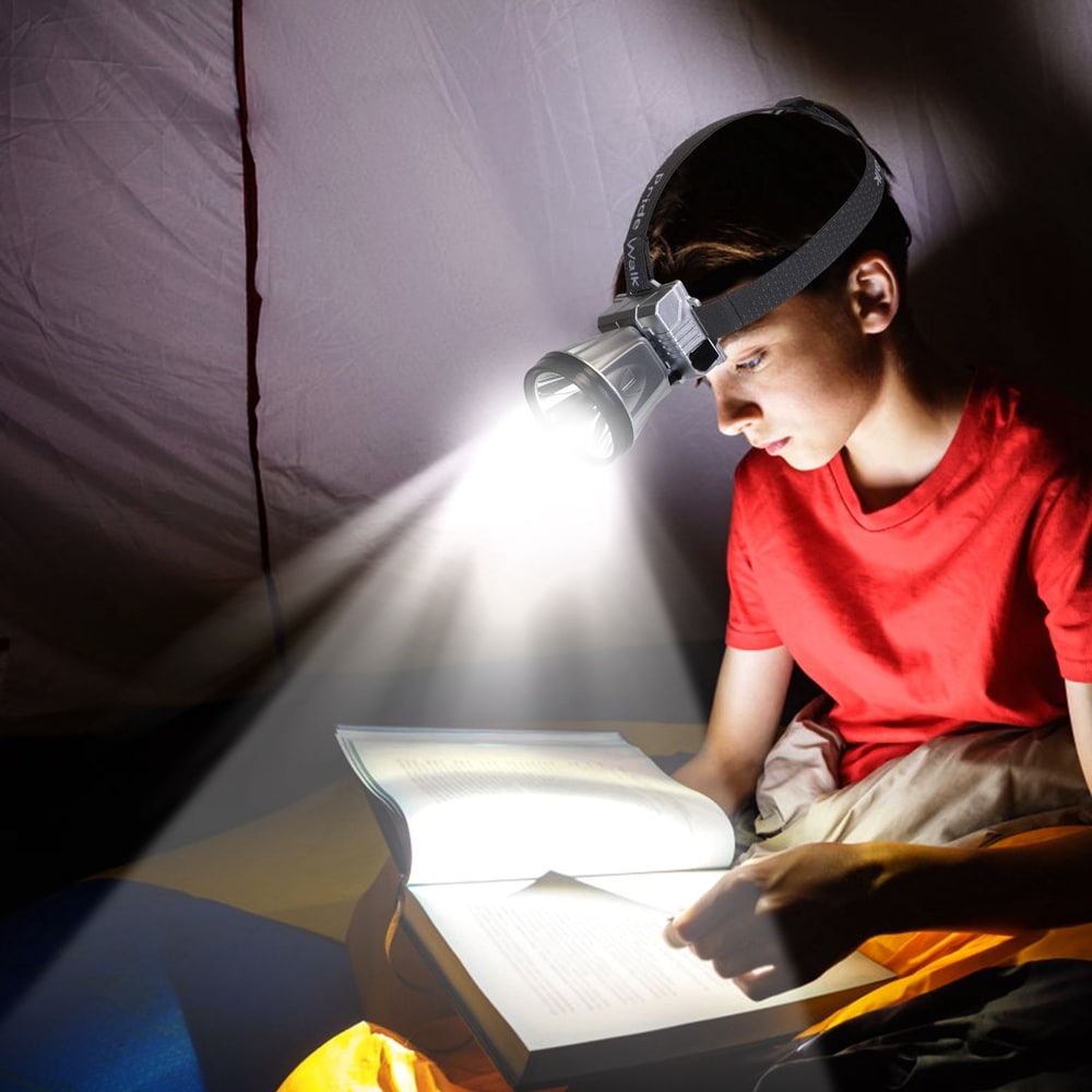 Headlamp illuminating a book, perfect for camping and outdoor reading in a tent, showcasing a child enjoying a cozy nighttime adventure.