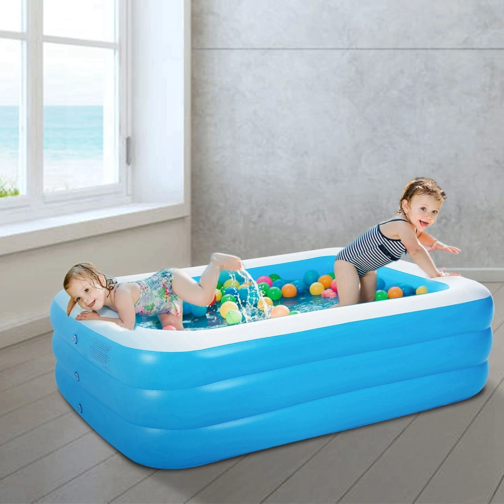 Inflatable kiddie pool filled with colorful plastic balls, featuring two children joyfully playing and splashing in a bright blue interior, with a coastal view through a window behind them.