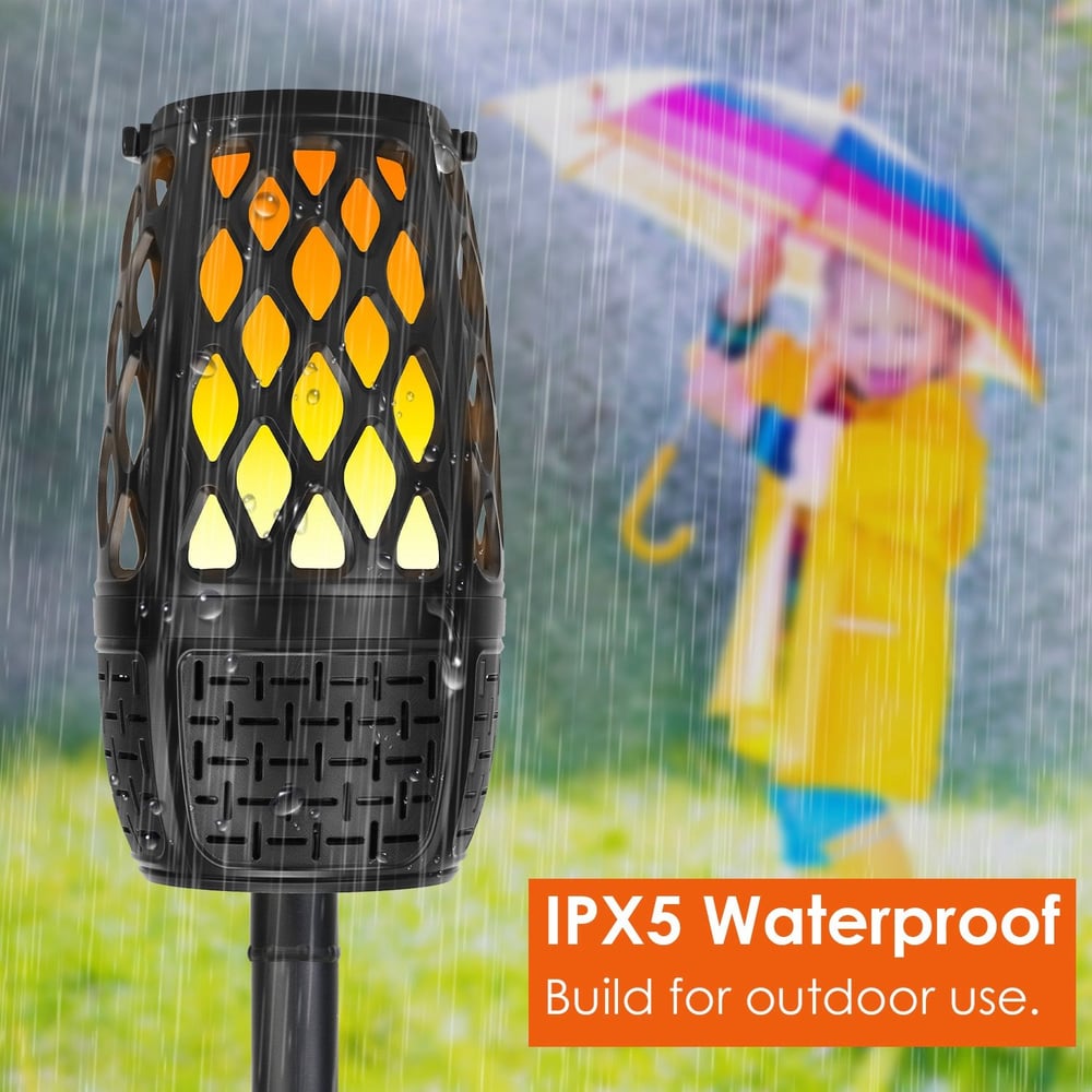 Outdoor waterproof torch light with IPX5 rating, designed to withstand rain, featuring a stylish black design and warm glowing amber lights, perfect for enhancing patio ambiance.