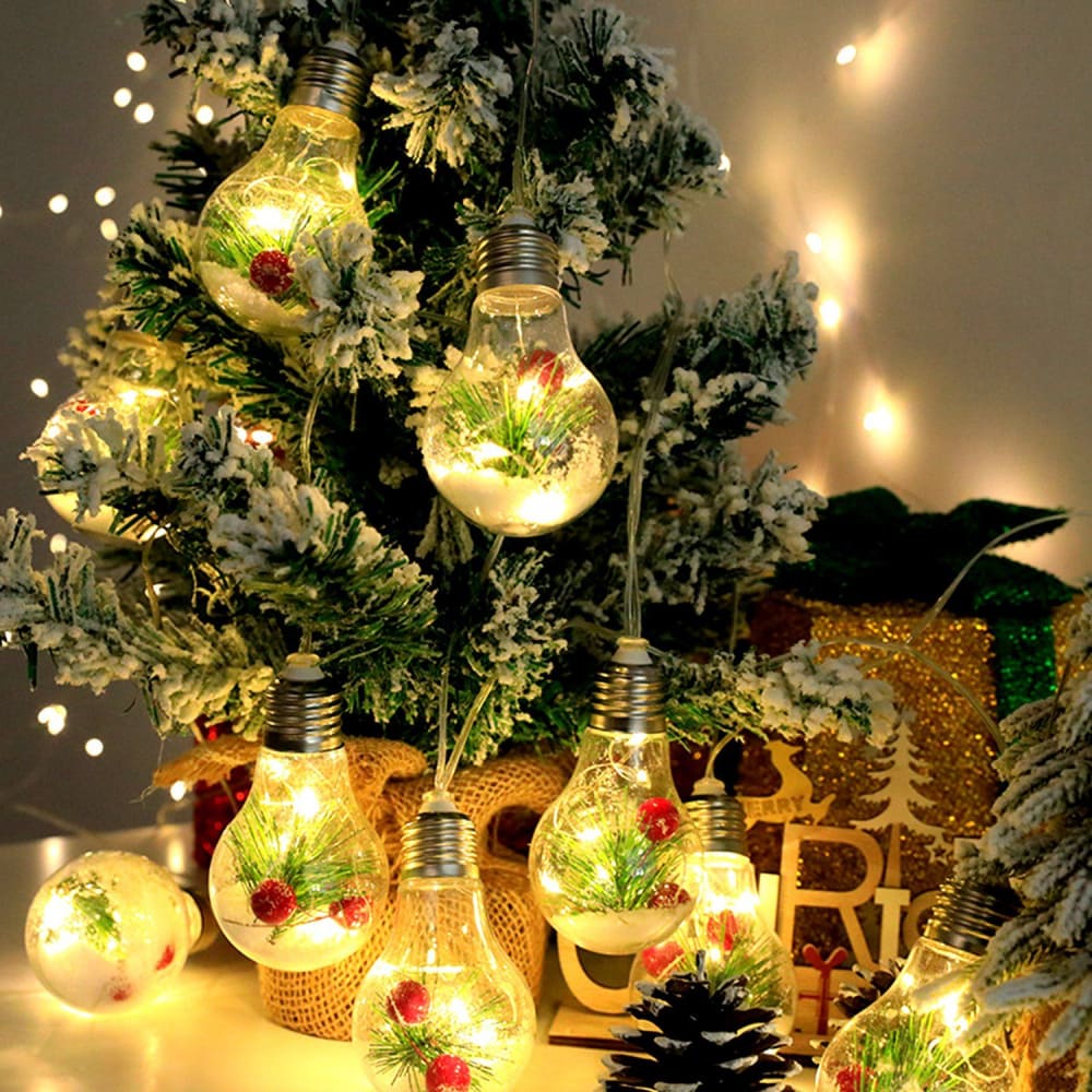 Christmas tree adorned with illuminated light bulb ornaments featuring snow, greenery, and red berries, creating a festive and cozy holiday atmosphere.