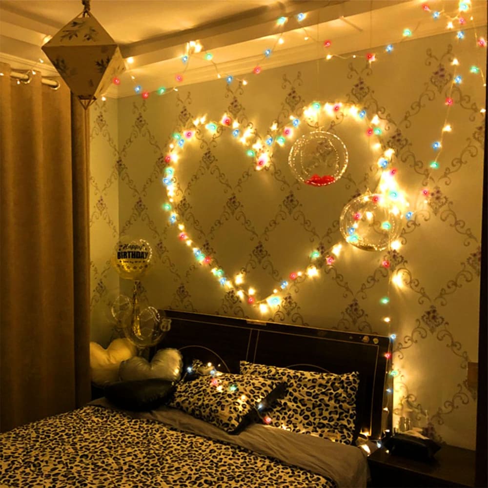 Cozy bedroom featuring a heart-shaped arrangement of colorful fairy lights on the wall, adorned with decorative balloons and a leopard print bedding set, creating a warm and inviting atmosphere.