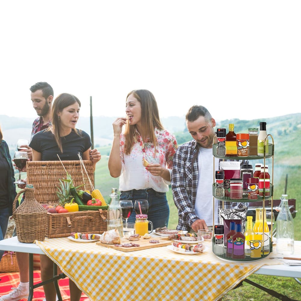 Outdoor picnic scene featuring a stylish, multi-tiered spice rack displaying various jars and bottles, with a vibrant yellow checkered tablecloth, fresh produce in a wicker basket, and a scenic green landscape in the background.