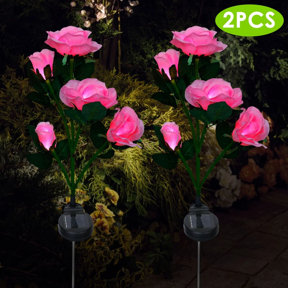Pink solar-powered LED rose lights set of 2 for garden decoration, showcasing vibrant artificial roses with green leaves against a dark background.